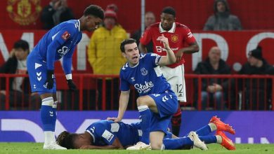 Alex Iwobi on the turf surrounded by Manchester United defender Tyrell Malacia and his teammates