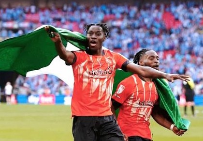 Elijah Adebayo and Fred Onyedimma celebrating with the Nigerian flag after the Championship playoffs final win