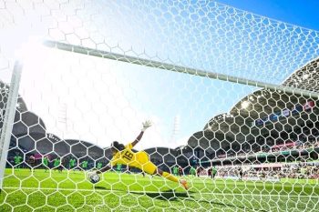 Chiamaka Nnadozie dives to save Christine Sinclair's penalty kick