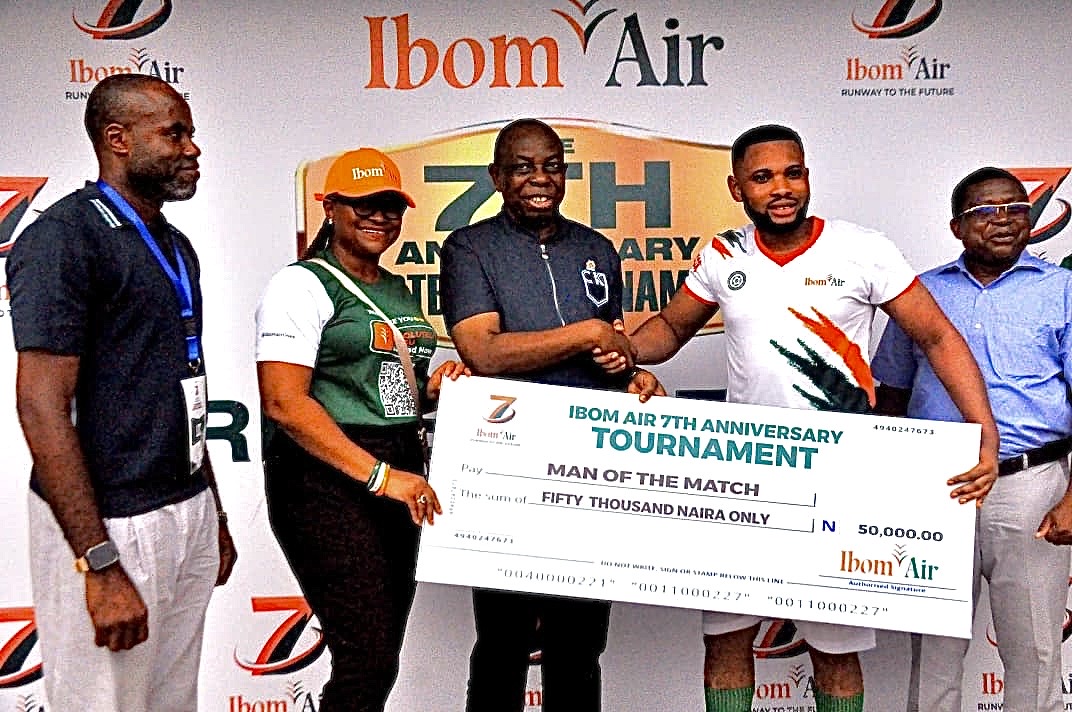 Elder Paul Bassey presents Elisha Asuquo with his Ibom Air anniversary tournament Man of the match award.