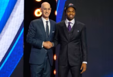 Ebuka Okorie poses with NBA Commissioner Adam Silver after being selected in the 2026 NBA Draft