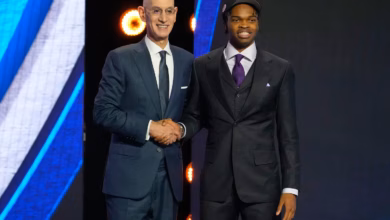 Ebuka Okorie poses with NBA Commissioner Adam Silver after being selected in the 2026 NBA Draft